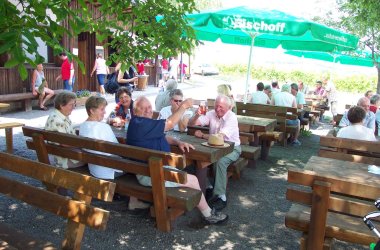 Sitzende Menschen bei der Weinwanderhütte